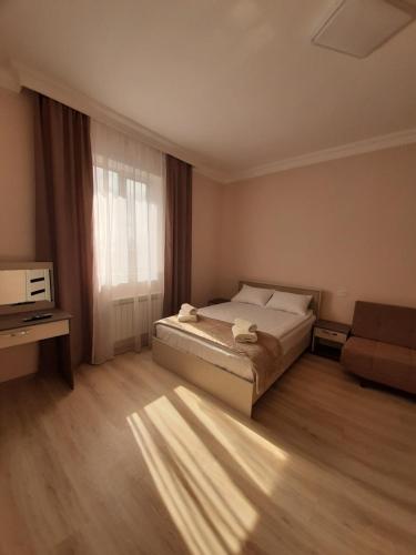 sypialnia z łóżkiem, telewizorem i oknem w obiekcie Vernatun guest house w mieście Giumri