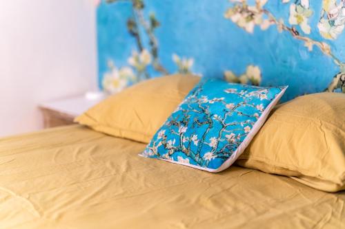 Una cama con una almohada azul encima. en L'ISLE D'OR - LES AMANDIERS - 3 étoiles - 1er étage, en LʼIsle-sur-la-Sorgue
