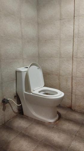 a bathroom with a toilet with the lid up at Le Grace Bye Pass in Madurai