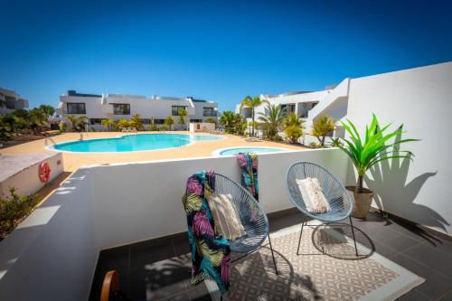 eine Terrasse mit zwei Stühlen und einem Swimmingpool in der Unterkunft Casilla de Costa in Villaverde