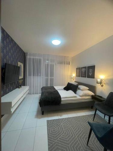 Geri Mini Home في زالاجيرسيج: غرفة نوم فيها سرير وتلفزيون