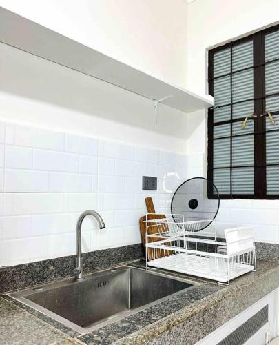 a kitchen sink with a dish drying rack on it at Family-Friendly Cabin Hideaway, Alfonso Tagaytay in Alfonso