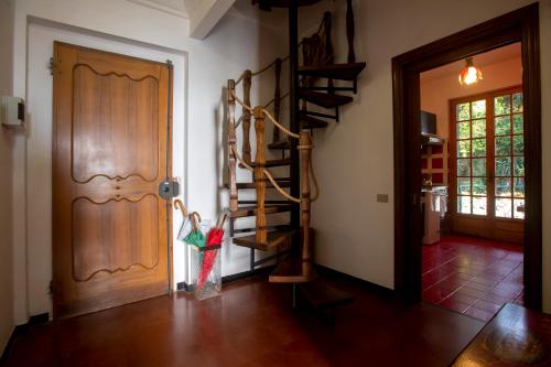 a hallway with a wooden door and a spiral staircase at 080 - La Villa storica Il Vigneto 45b, Terrazza sul Mare - Parcheggio privato GRATIS in Moneglia