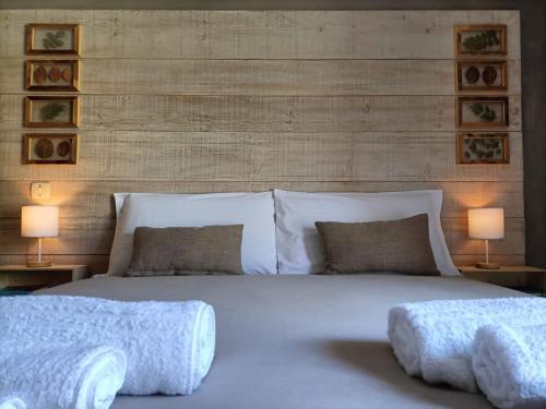 um quarto com uma cama grande e 2 candeeiros em Bed & Bike Frasassi em Falcioni