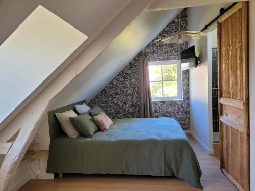 1 dormitorio con 1 cama en el ático en Les Fabulettes, en Auffay
