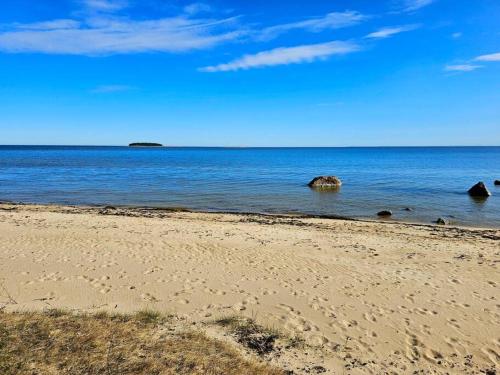 a beach with some rocks in the water at Rannamaja kümblustünni & saunaga in Haapse