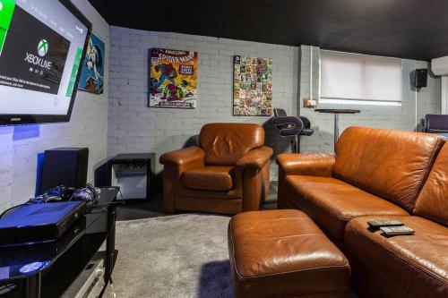 a living room with leather furniture and a flat screen tv at City home with parking and garden- pet friendly in Chester