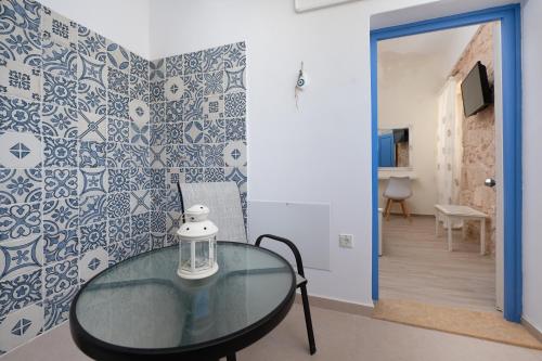 a glass table in a room with blue and white tiles at gdk house in the heart of Aegina in Aegina Town