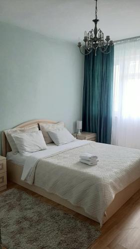 - une chambre avec un grand lit et un lustre dans l'établissement Апартаменты с видом на горы, à Almaty