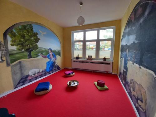 a room with a red carpet and a large window at instantSleep Backpackerhostel St Pauli in Hamburg