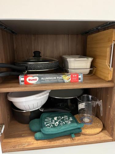 une armoire remplie de vaisselle et d'autres ustensiles de cuisine dans l'établissement Appartement 6 personnes Strasbourg proche centre ville & parking, à Strasbourg