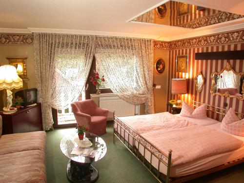 1 dormitorio con 1 cama, 1 silla y 1 sofá en Hotel Kempenhof, en Lügde