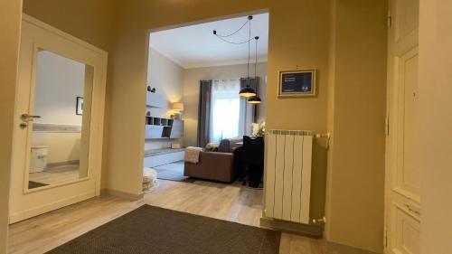 een hal met een woonkamer met een bank en een raam bij Siwa Home Experience in Anzio