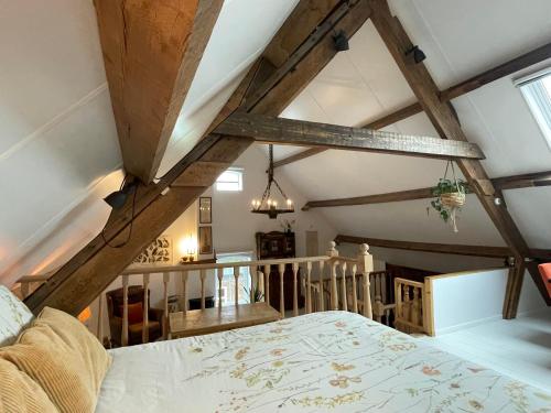 een slaapkamer met een bed in een kamer met houten plafonds bij B&B droom in de polder -DE SALON- luxe appartement met prive-sauna in Arnemuiden