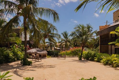 a courtyard with benches and palm trees in a resort at Moriá Eco Lodge in Icaraí