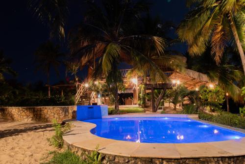 a swimming pool in front of a house at night at Moriá Eco Lodge in Icaraí