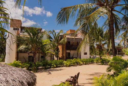 a building on the beach with palm trees at Moriá Eco Lodge in Icaraí