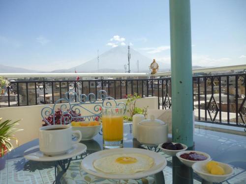una mesa con desayuno y bebidas en el balcón en Hotel San Francisco INN en Arequipa
