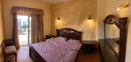 a bedroom with a bed with purple sheets and a window at Bahga Palace 3 Residential Apartments in Hurghada