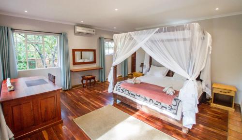 a bedroom with a bed with a canopy at Beautiful home overlooking a park - 2097 in Victoria Falls