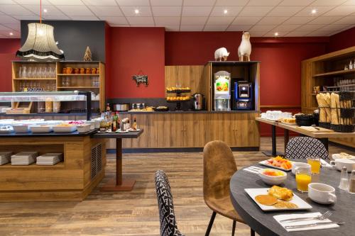 a restaurant with a table with food on it at SOWELL Family La Lauzière in Aime La Plagne