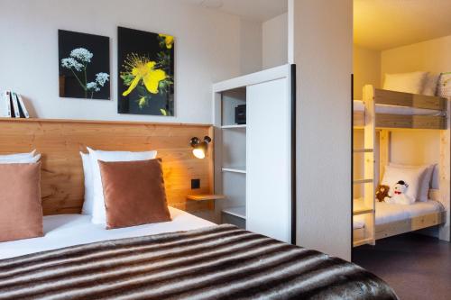 a bedroom with a bed and bunk beds at SOWELL Family La Lauzière in Aime La Plagne