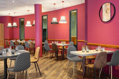 a restaurant with tables and chairs and pink walls at SOWELL Family La Lauzière in Aime La Plagne