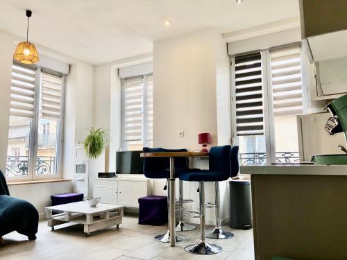 - un salon avec une table et quelques fenêtres dans l'établissement joli appart au centre de Lyon, à Lyon