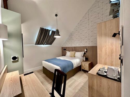 a bedroom with a bed and a desk in a room at The Pillar Hotel in London