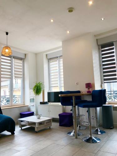 un salon avec une table, des chaises et des fenêtres dans l'établissement joli appart au centre de Lyon, à Lyon