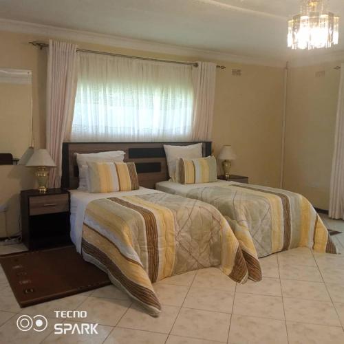 two beds in a hotel room with two beds sidx sidx sidx at Guesthouse with green garden and pool - 2102 in Harare