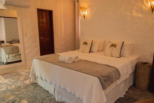a bedroom with a large bed with towels on it at Moriá Eco Lodge in Icaraí