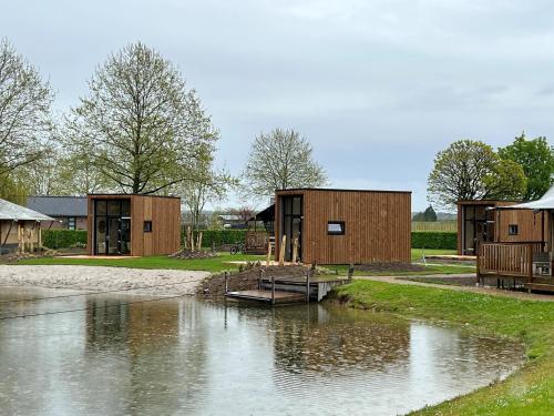 a couple of buildings next to a river at Tiny House in Kesteren