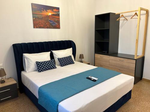 Technopolis Luxury Apartments في أثينا: غرفة نوم بها سرير وخزانة فيها ريموت كنترول
