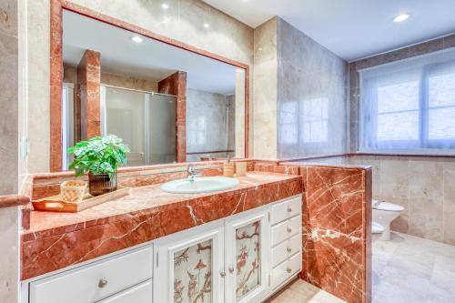 a bathroom with a sink and a mirror at Deluxe relax apartment with pool in Estepona