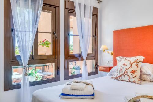 a bedroom with a bed and two windows at Deluxe relax apartment with pool in Estepona