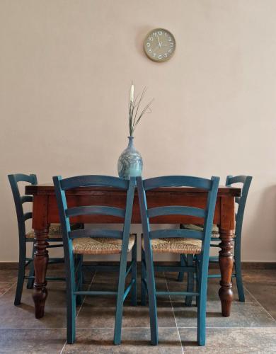 a table with two chairs and a vase on it at Mister Barolo Apartments Langhe in Novello