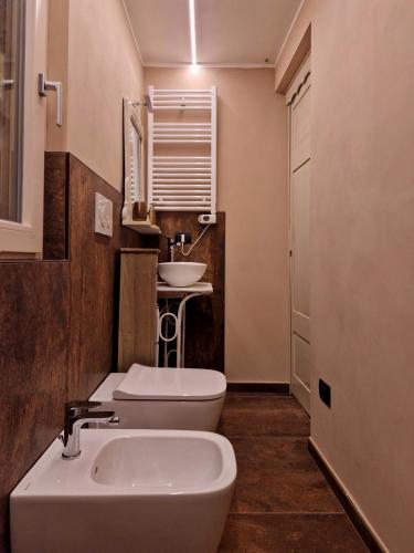 a bathroom with a white sink and a toilet at Mister Barolo Apartments Langhe in Novello