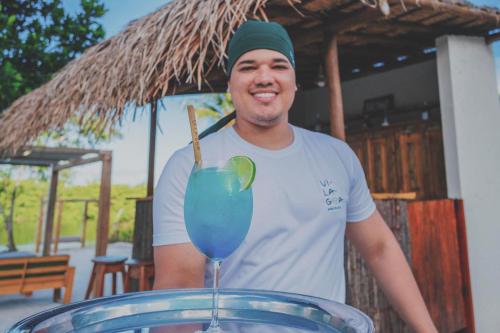 a man standing in front of a blue drink at Pousada Vilagoa in Coqueiro Sêco