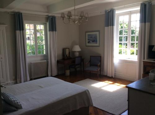 une chambre avec un lit et deux fenêtres dans l'établissement Le clos saint Genois, à Saint-Genis-Laval