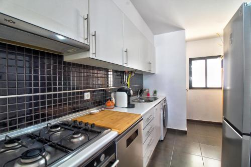 a kitchen with white cabinets and a stove top oven at Center location, AC, swimming pool, and parking in Olhão