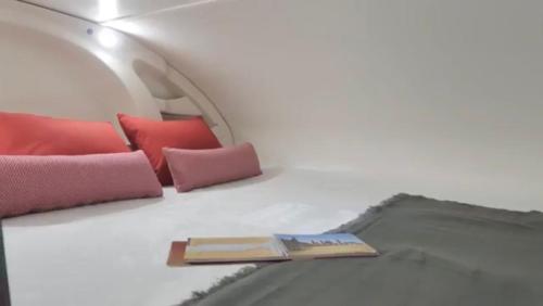 un libro sobre una cama con almohadas en Portugals Infinity - AutoCaravana Luxo, en Faro