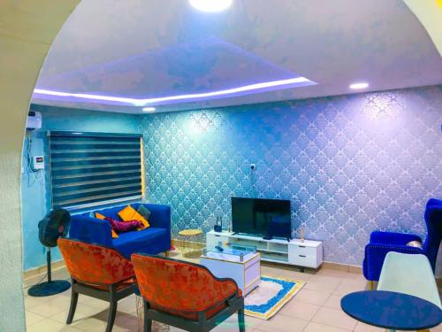 - un salon avec un canapé et une télévision dans l'établissement Triple Dee Shortlet Apartments, Omole phase 1, Lagos, à Lagos