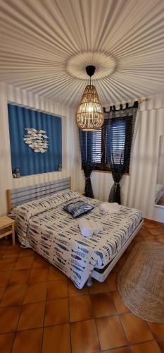 una camera con letto e lampadario a braccio di La Casa sulla Spiaggia a Marzamemi