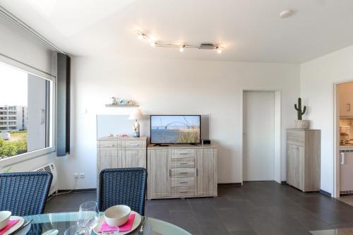 a dining room with a television and a table and chairs at Burgtiefe Südstrand "Seestern" in Fehmarn