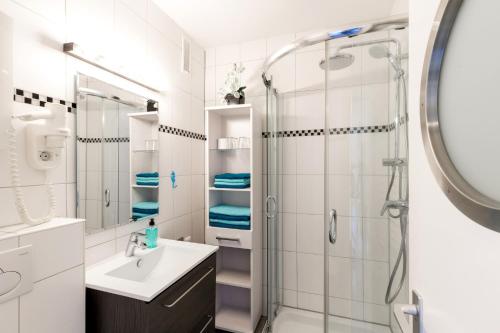 a white bathroom with a sink and a shower at Burgtiefe Südstrand "Seestern" in Fehmarn