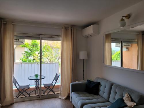 ein Wohnzimmer mit einem Sofa und einem Tisch in der Unterkunft Claelle Appartment - 300m beach in Mandelieu-la-Napoule