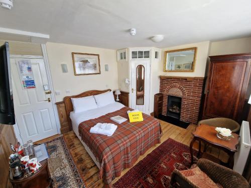 a bedroom with a bed and a fireplace at Black Horse Canterbury in Canterbury