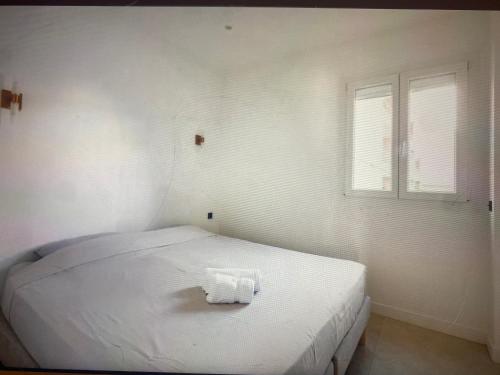 een wit bed in een kamer met 2 ramen bij Appartement Avec Terrasse Centre-ville Croisette in Cannes