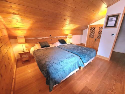 ein Schlafzimmer mit einem Bett in einer Holzhütte in der Unterkunft Appartement Le D12 Samoëns in Samoëns
